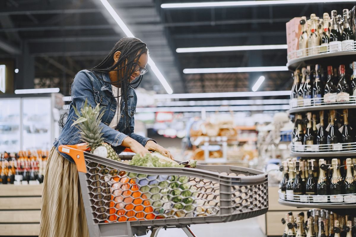 Una mujer elige productos de una góndola del supermercado.