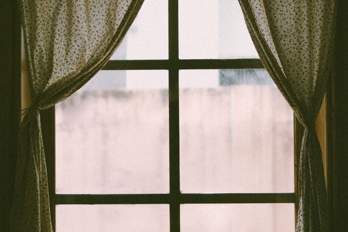 La luz natural atraviesa unas cortinas junto a la ventana.