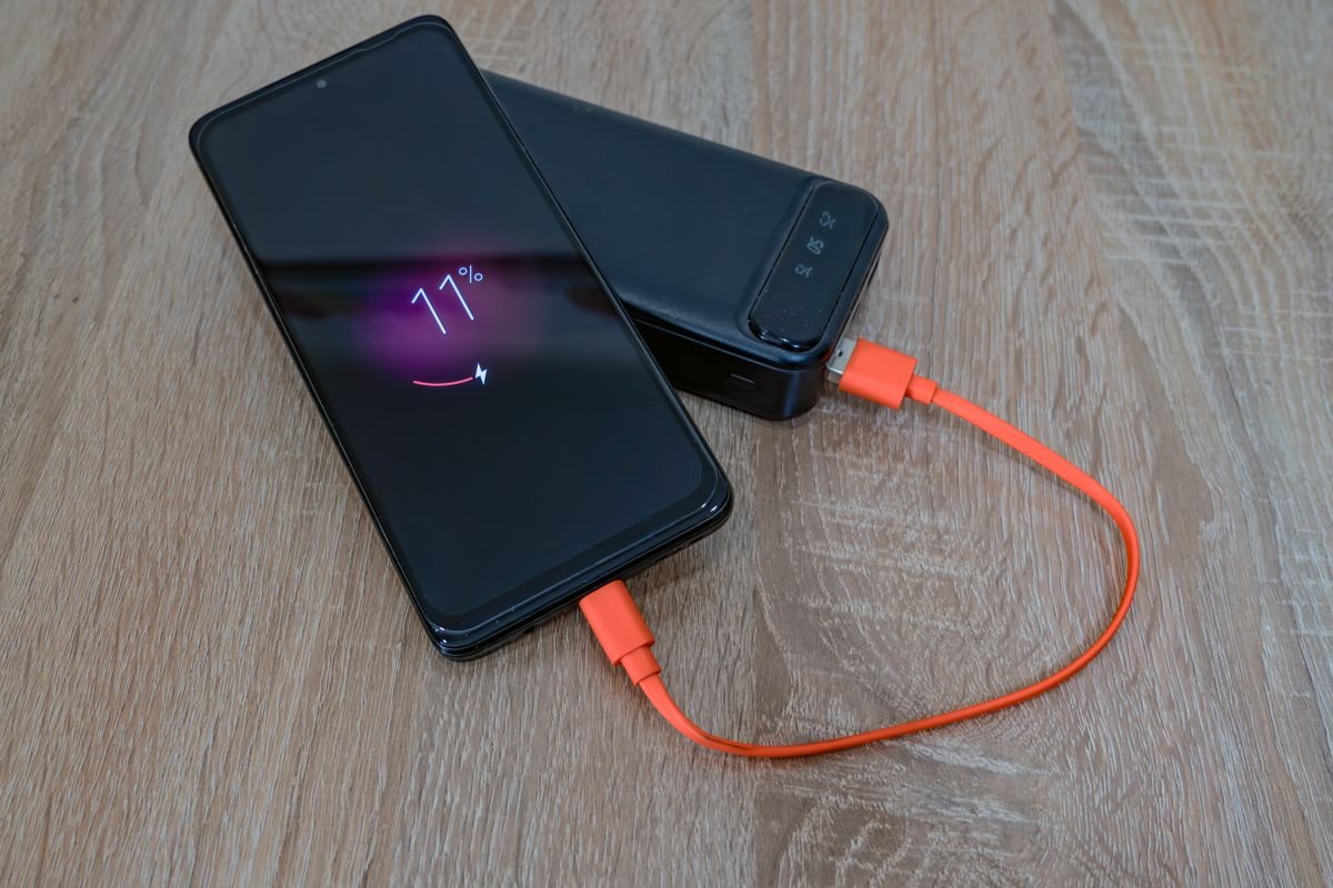Un teléfono móvil se carga con una batería portátil.