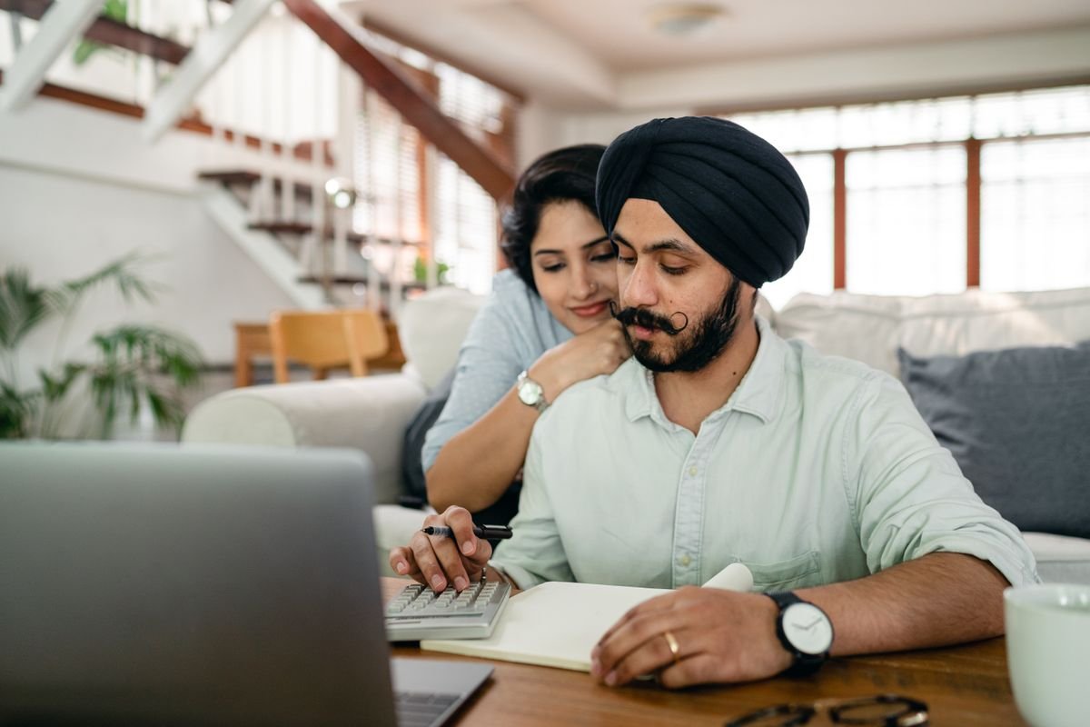 Una pareja revisa las cuentas del hogar con una calculadora.