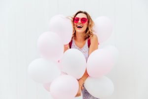 Cheerful girl having fun while holding balloons